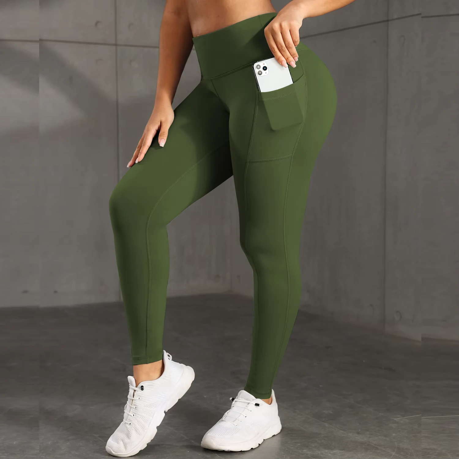 femme portant un legging de fitness vert avec poche latérale